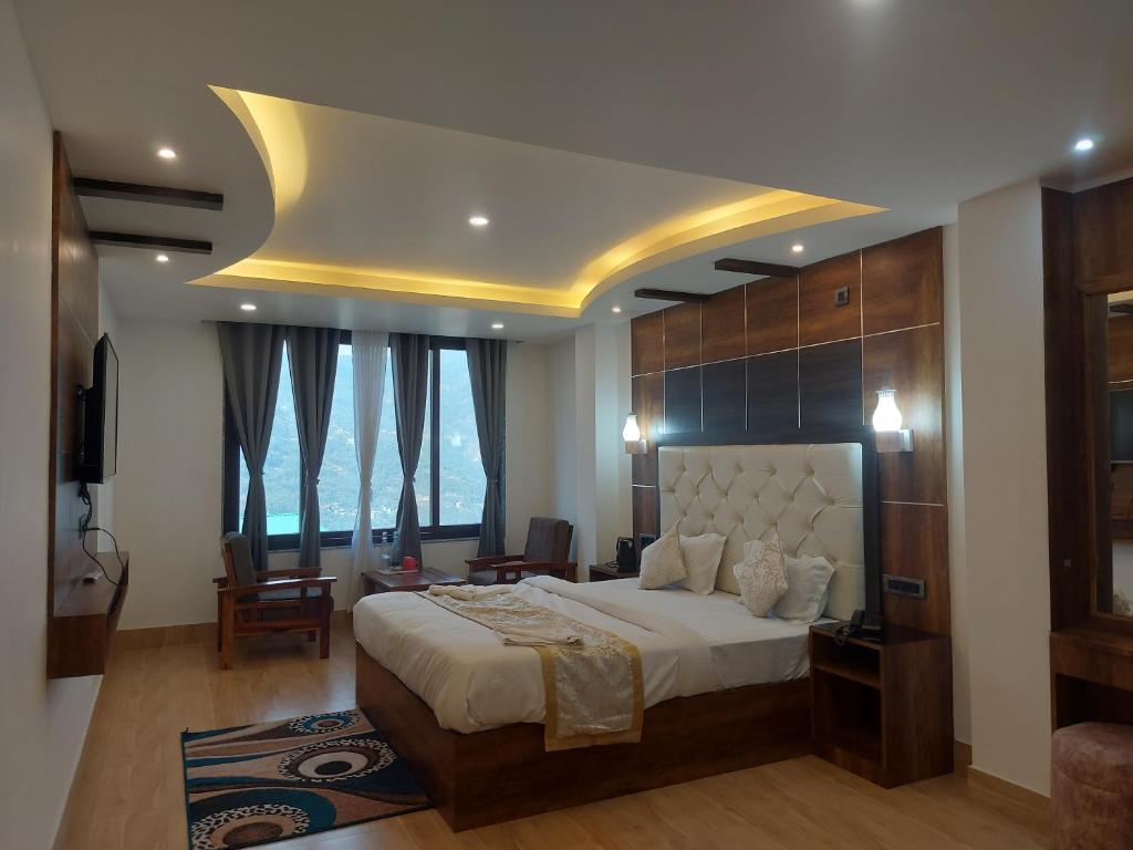 a bedroom with a large bed and a large window at Hotel Sikkim Legend in Gangtok