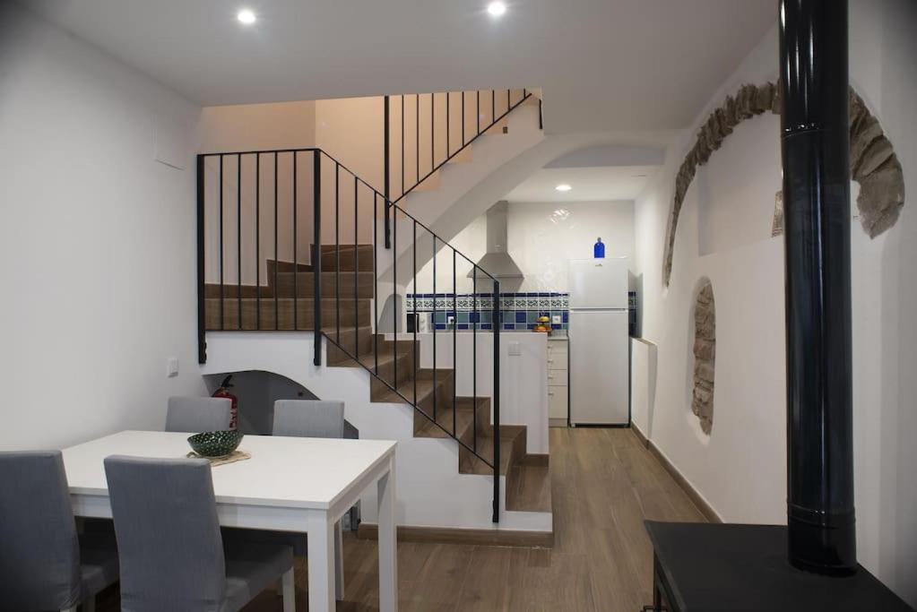 a dining room with a staircase and a table at Casa Rural Ana Maria Ain in Ahín