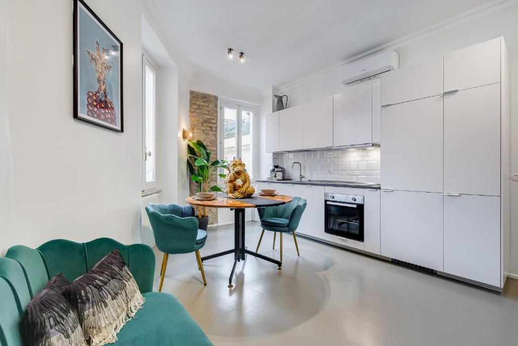 a kitchen with white cabinets and a table and chairs at Klioos Apartment Testaccio in Rome