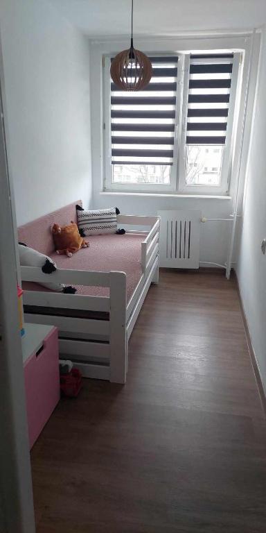 sypialnia z łóżkiem i dużym oknem w obiekcie Jakuba Wejhera 5c 10 w Gdańsku