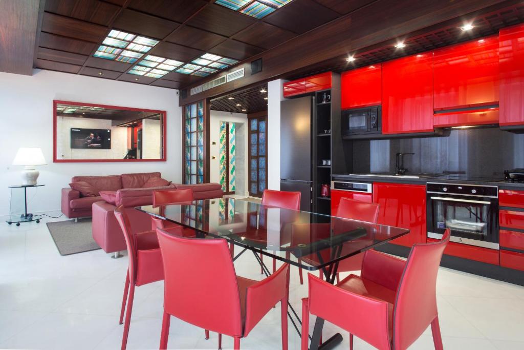 a kitchen with red cabinets and a glass table and chairs at Verona apt.65 in Verona