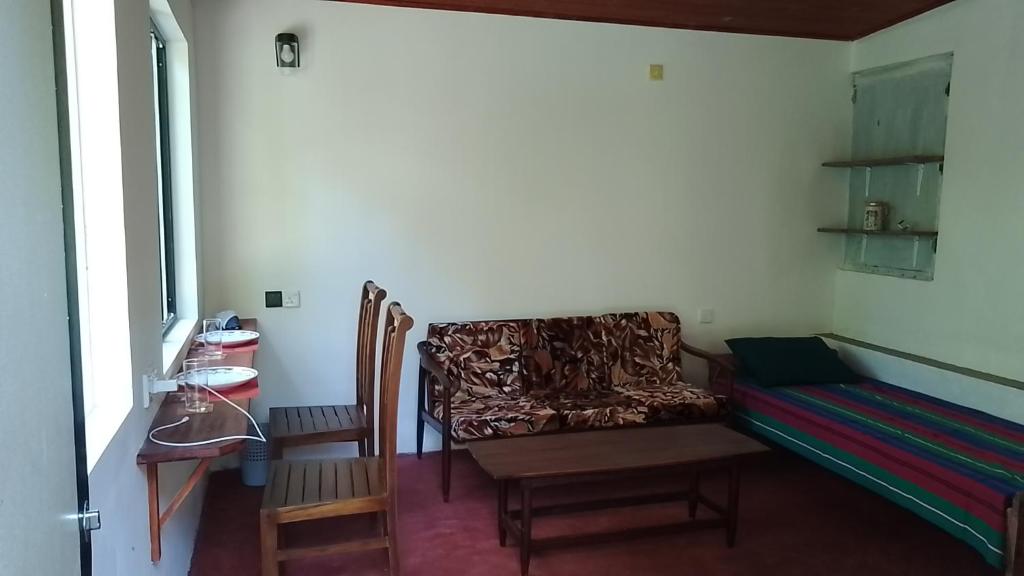 ミリッサにあるRainbow mountain villaのソファ、椅子、テーブルが備わる客室です。