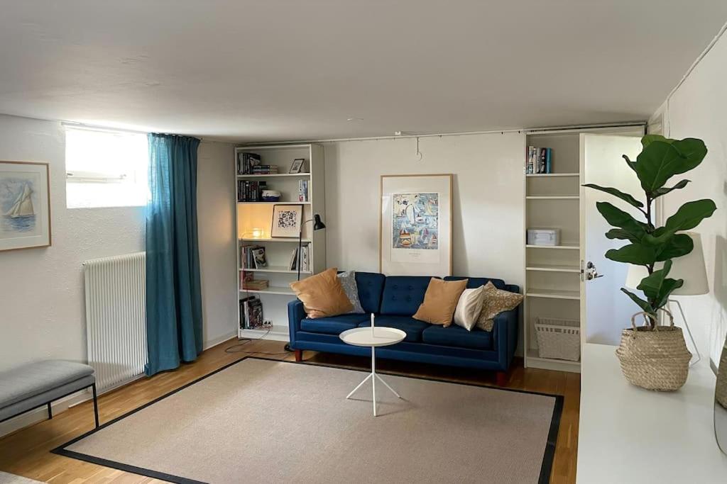 uma sala de estar com um sofá azul e uma mesa em Limhamn city-ocean em Limhamn