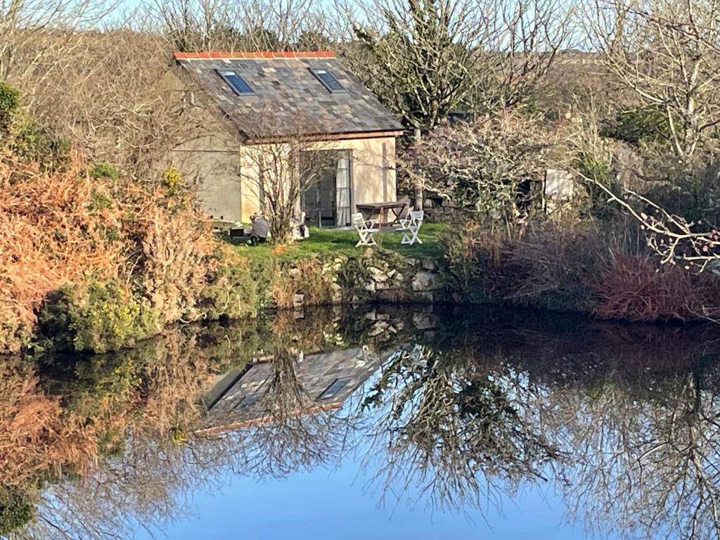 una casa junto a un río con su reflejo en el agua en Tresahor Studio, en Falmouth