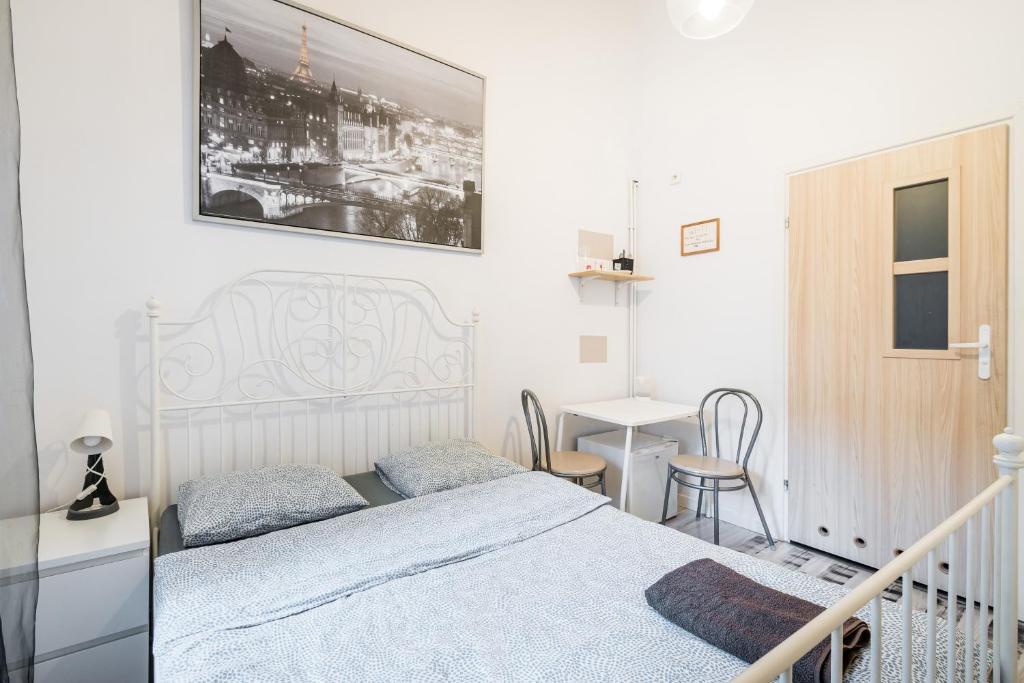 een witte slaapkamer met een bed en een tafel bij Laykonik in Krakau