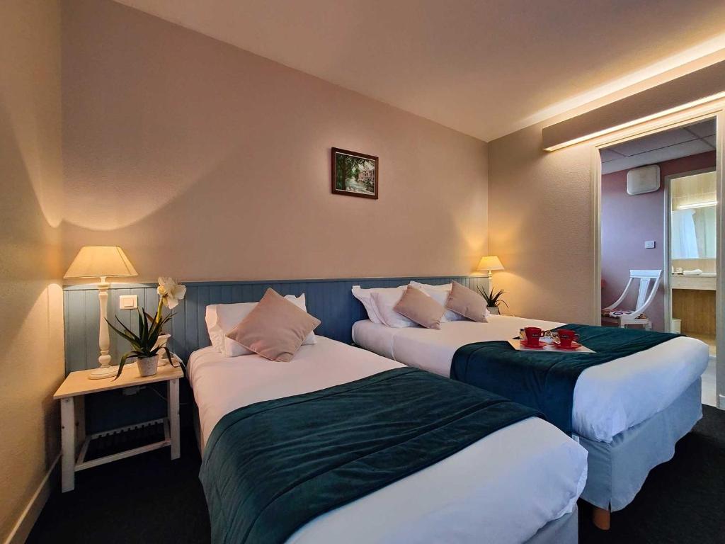 Postel nebo postele na pokoji v ubytování Logis Hôtel Cartier