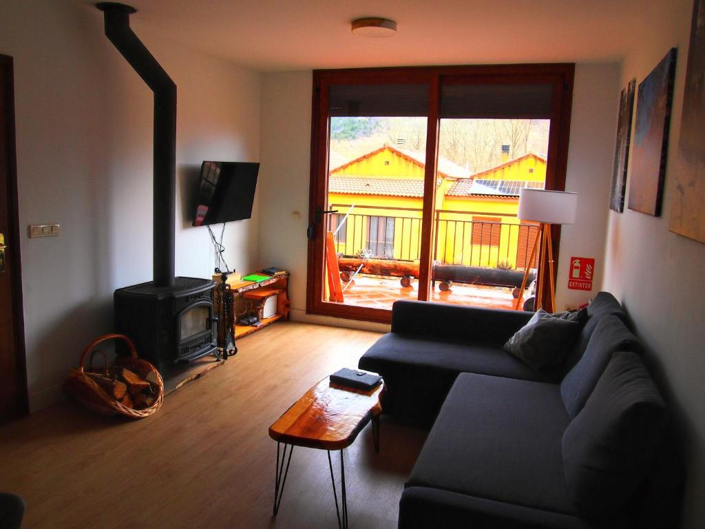 a living room with a couch and a wood stove at Alojamiento Rural Los Hacheros in Tragacete