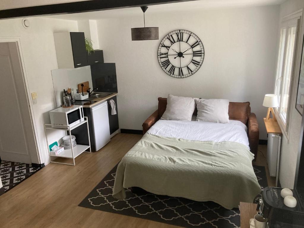 - une chambre avec un lit et une horloge murale dans l'établissement Appartement cosy, à Saint-Sébastien-sur-Loire