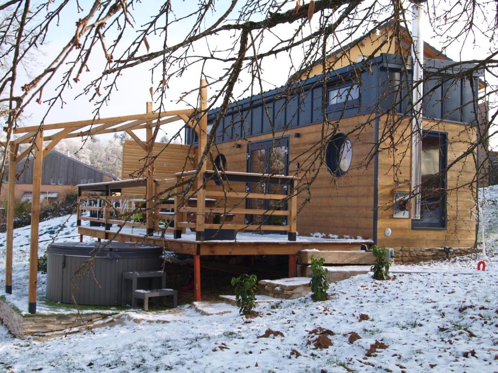une cabane en rondins avec une terrasse dans la neige dans l'établissement Chez Mado, à Frémifontaine