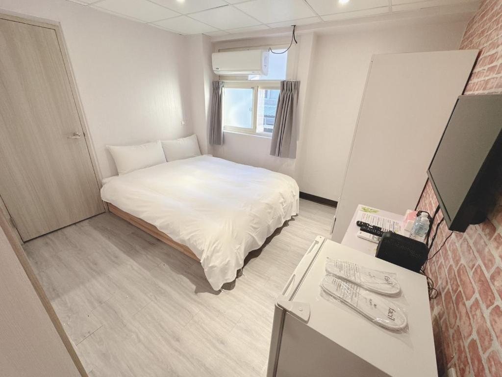 Postel nebo postele na pokoji v ubytování 新獅城商務旅館New Lion City Hotel
