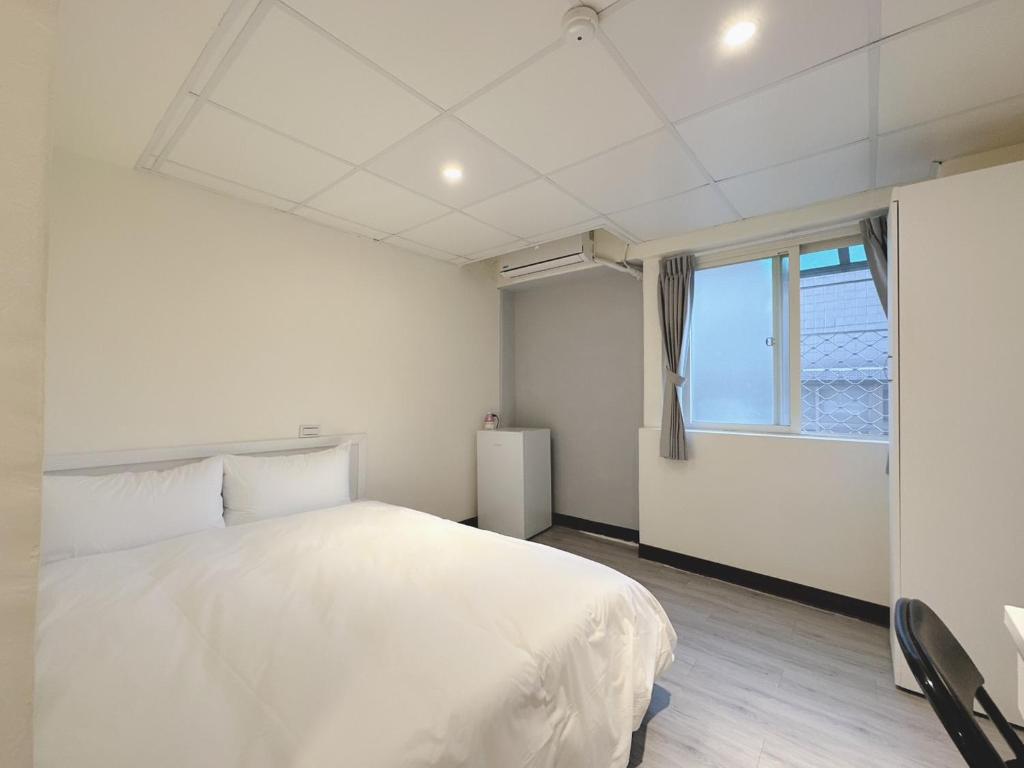 Postel nebo postele na pokoji v ubytování 新獅城商務旅館New Lion City Hotel