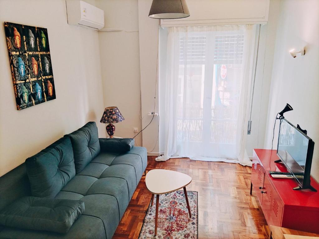 un soggiorno con divano verde e tavolo di Selini's apartment ad Atene