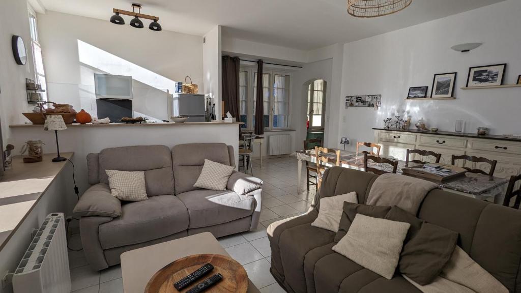 a living room with two couches and a kitchen at Appartement montagne in Eaux-Bonnes