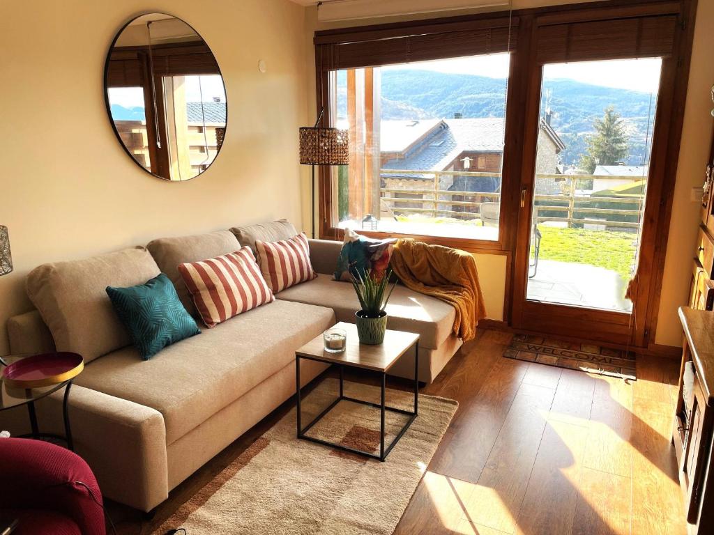 un salon avec un canapé et une table dans l'établissement Apartamento renovado con jardín privado, parking ,wifi y piscina, à Osséja