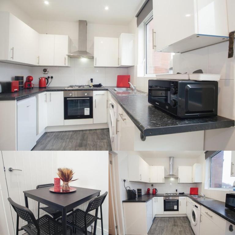 a kitchen with white cabinets and a black table at Central Location Modern Furnishing Families and Contractors in Sheffield