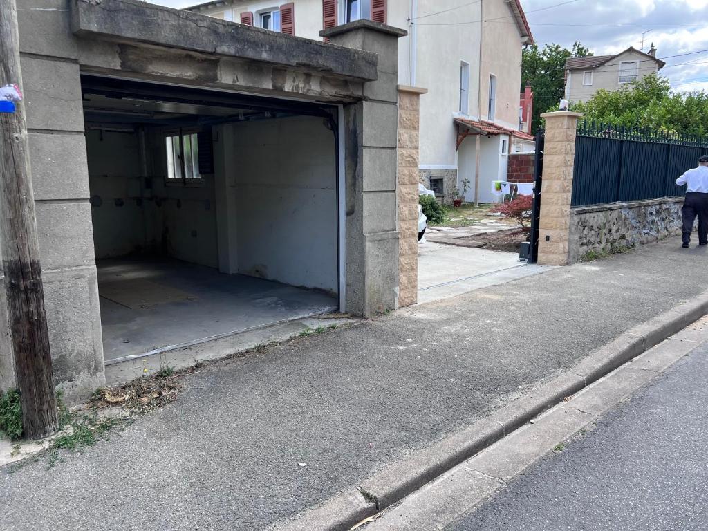 an open garage on the side of a street at Maison Climatisée 04 chambres Paris Disney CDG in Gagny