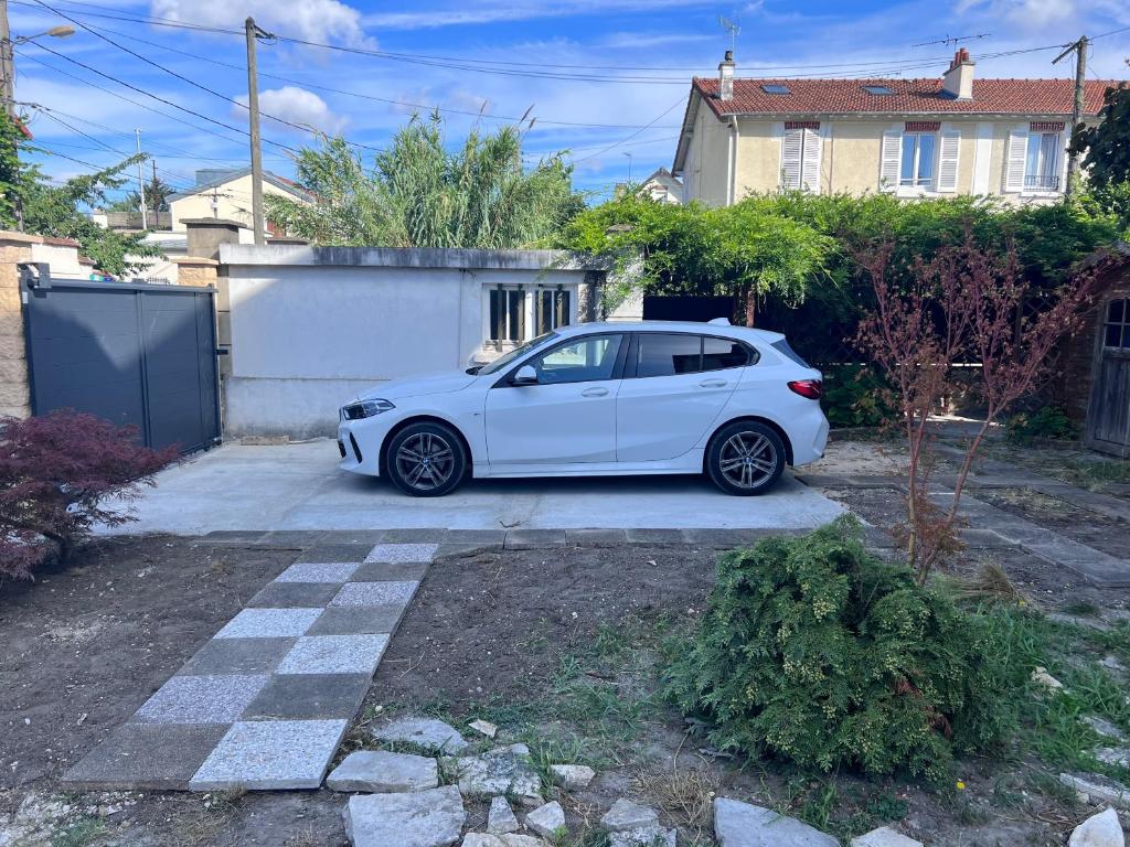 a white car parked in front of a house at Maison Climatisée 04 chambres Paris Disney CDG in Gagny