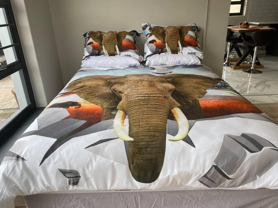 un letto con una testa di elefante sopra di Elephant Lodge a Hermanus