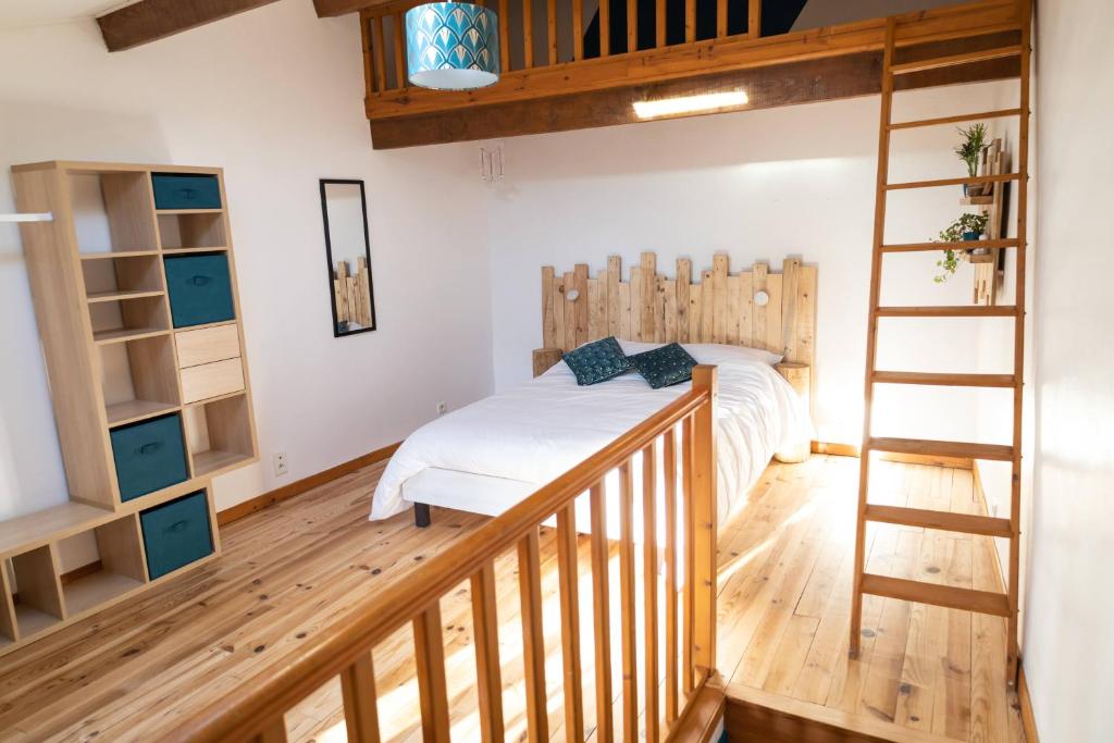 ein Schlafzimmer mit einem Bett und einer Holztreppe in der Unterkunft La Vigère in Mirefleurs