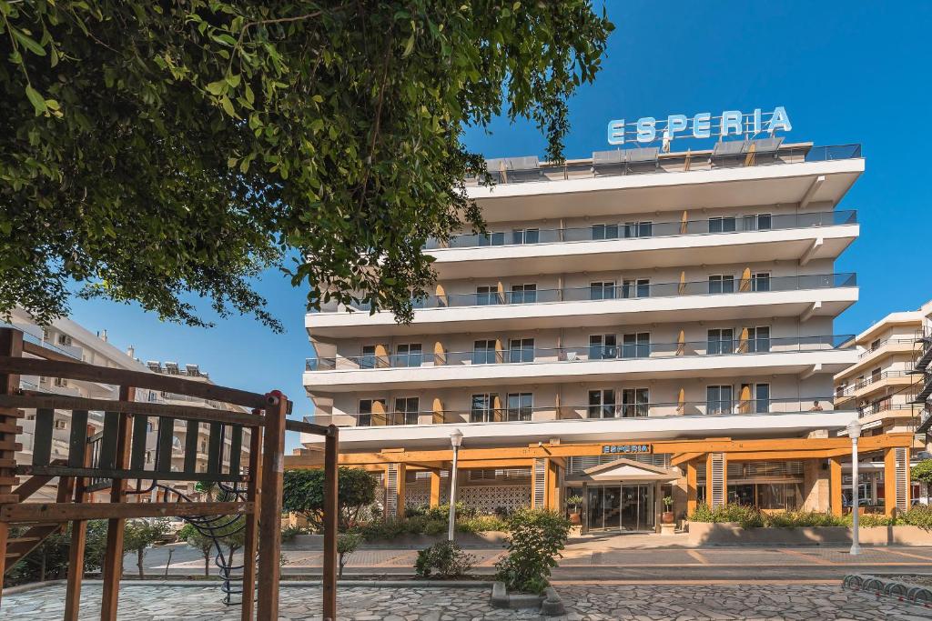 een groot wit gebouw met een bord erop bij Esperia City Hotel in Rhodos-stad