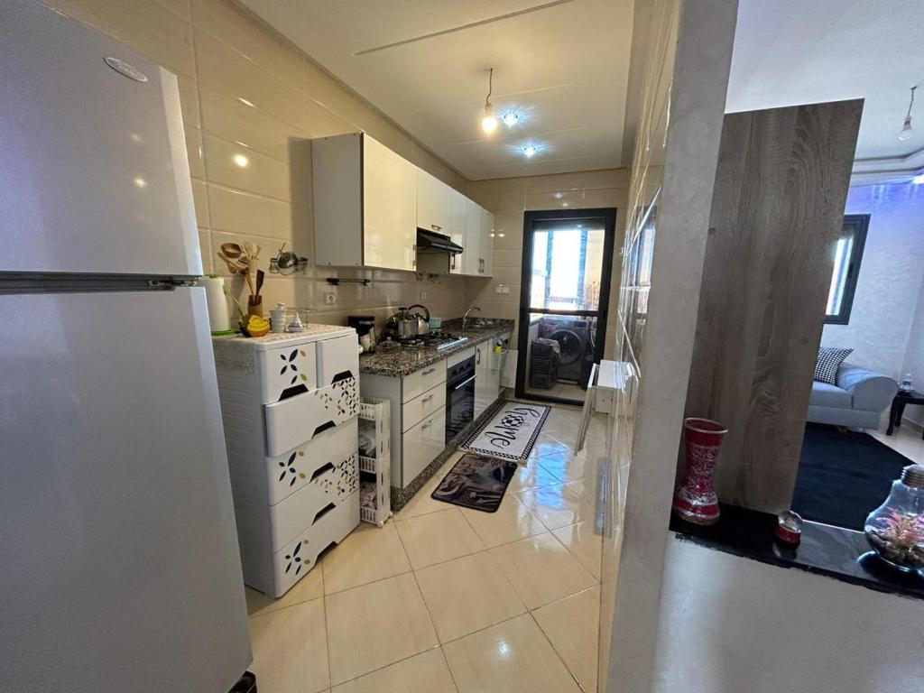 eine Küche mit einem Kühlschrank und einem Herd Top-Backofen in der Unterkunft Appartement Aéroport Casablanca in Dah Hammou Ben Cheïkh