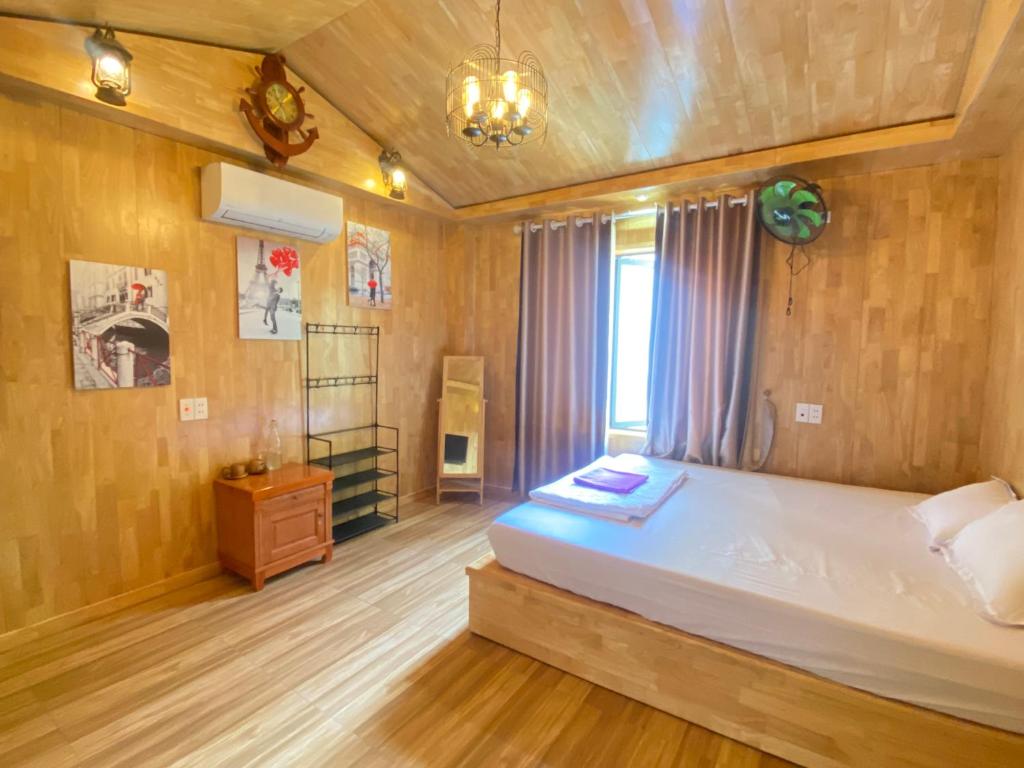 a bedroom with a large white bed in a room at Tropicana Homestay in Cat Ba