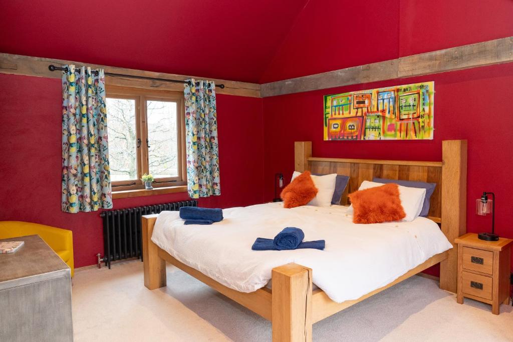 BletchingleyにあるJossie's Snugの赤い壁のベッドルーム1室(大型ベッド1台付)