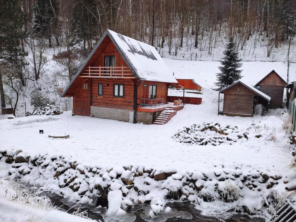 Cabaña de madera con nieve en el suelo en Lawendowe wzgórze, en Pieszyce