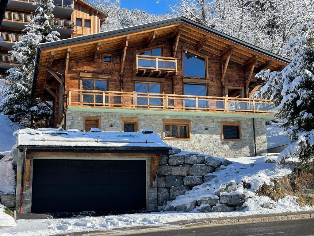 a log home in the snow with a garage at Chalet L'Alpaga in Châtel