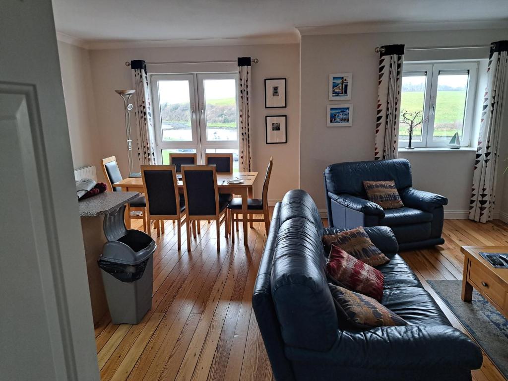 ein Wohnzimmer mit einem Sofa, einem Tisch und Stühlen in der Unterkunft 203 Harbour Mill in Westport