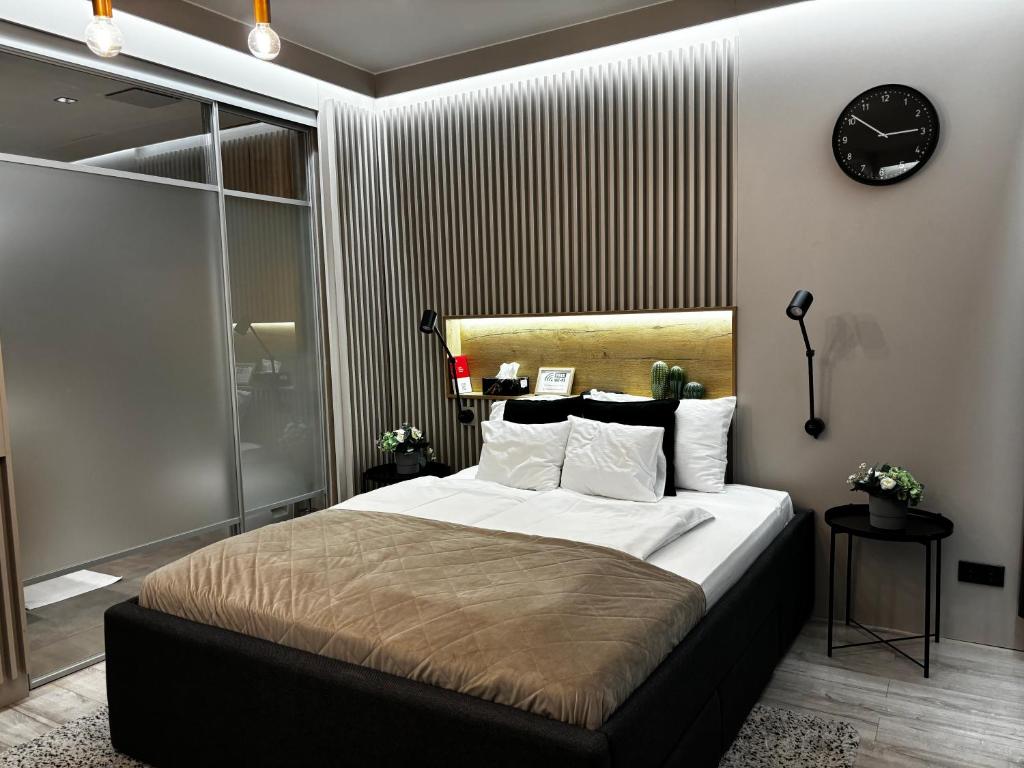 a bedroom with a large bed with a clock on the wall at K40 Residence, with pool on the top! in Budapest