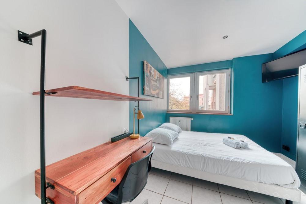 ein Schlafzimmer mit einem Bett und einem Schreibtisch. in der Unterkunft Atelier-Gerland in Lyon