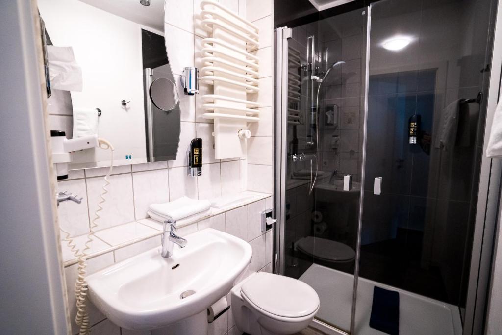 a bathroom with a sink and a toilet and a shower at Trip Inn Parkhotel Bad Ems in Bad Ems