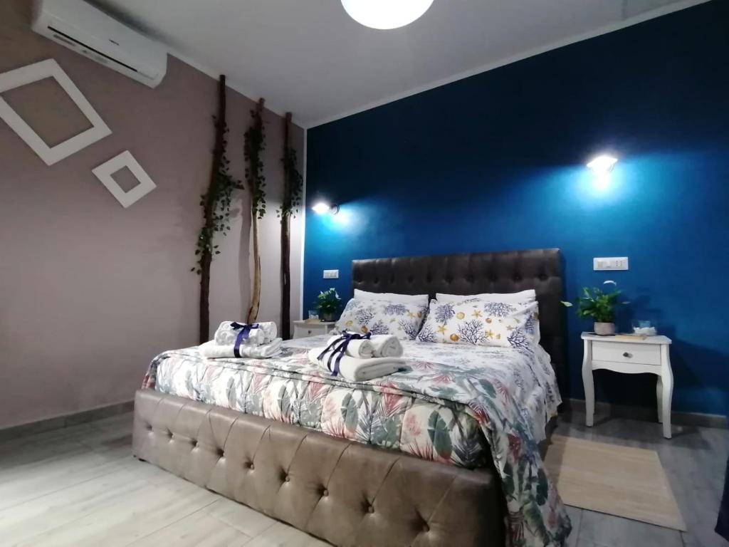 um quarto com uma cama com uma parede azul em Dimora Bed and Breakfast em San Gavino Monreale