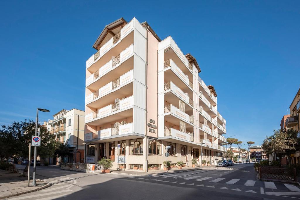 um edifício de apartamentos na esquina de uma rua em Lola Piccolo Hotel e Appartamenti em Marina di Grosseto