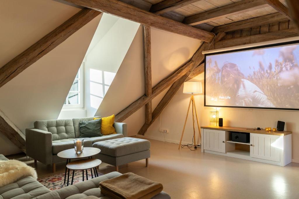 ein Wohnzimmer mit einem großen Bildschirm im Dachgeschoss in der Unterkunft Ferienwohnung in der alten Brauerei in Schwäbisch Hall