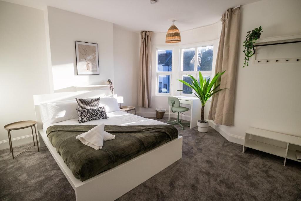 a bedroom with a large white bed and a window at Dallow Rd Serviced Accommodation in Luton