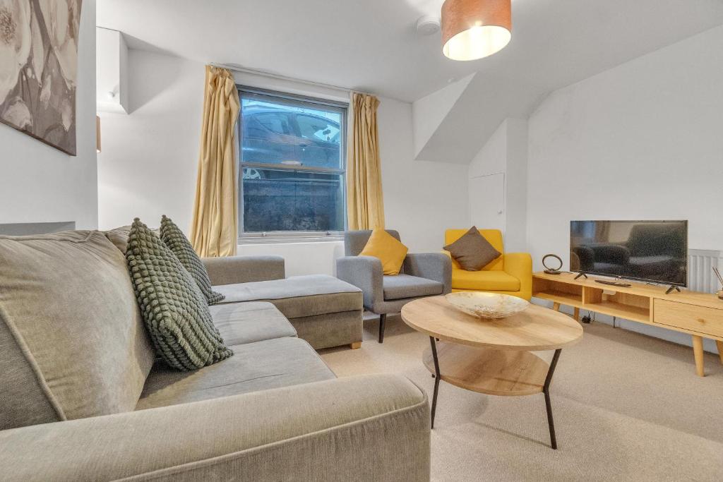 ein Wohnzimmer mit einem Sofa und einem Tisch in der Unterkunft Seaside Sanctuary House By My Getaways in Brighton & Hove
