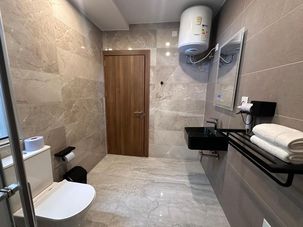 a bathroom with a toilet and a sink at La Bella Guesthouse in St. Julianʼs
