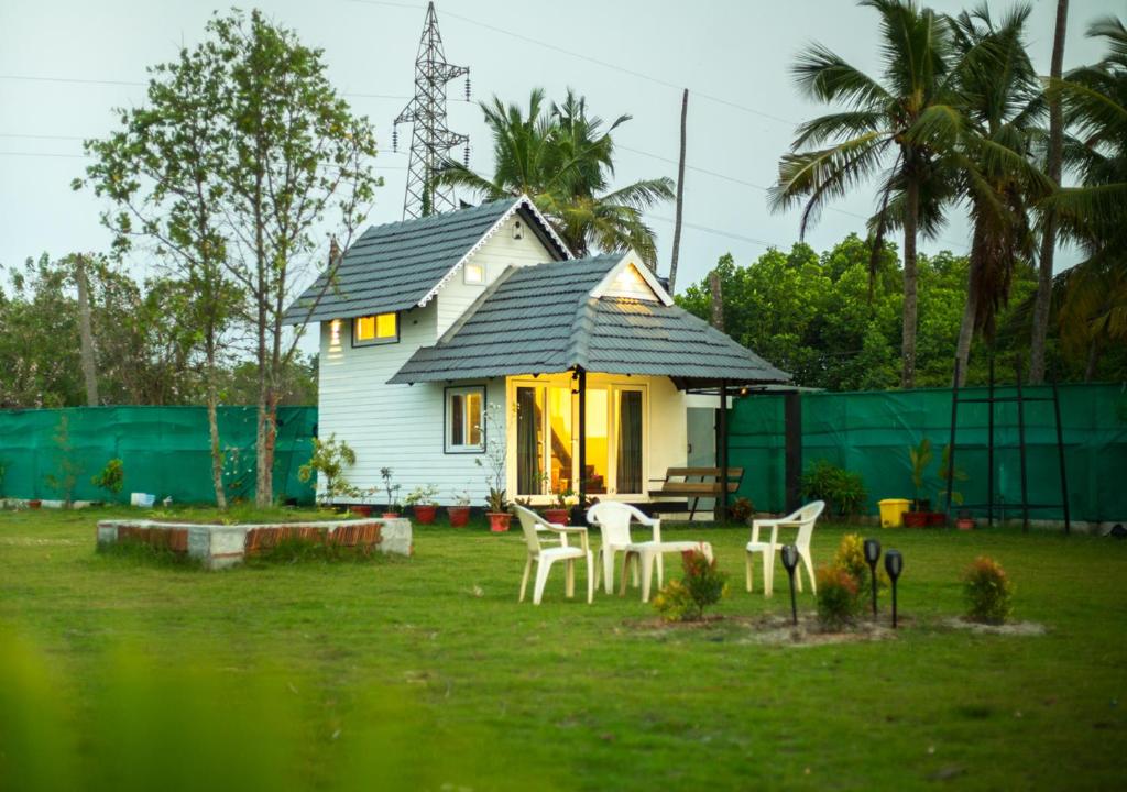 a small house with a table and chairs in a yard at JC Den Kochi Villas by VOYE HOMES in Cochin