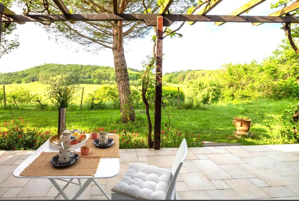 a patio with a table and chairs and a view of a field at Les pieds en éventail in Lignairolles