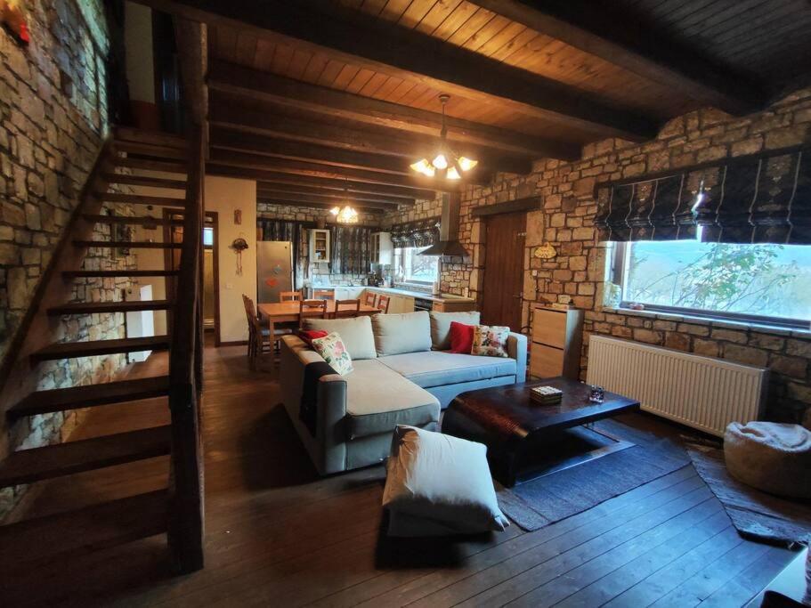 un soggiorno con divano e muro di mattoni di Erymanthos country home a Kalavrita