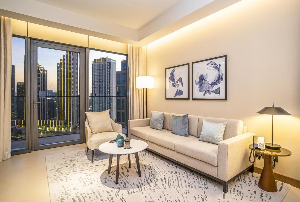 een woonkamer met een bank en een tafel bij Vacay Lettings Luxury Living Address Opera Downtown in Dubai