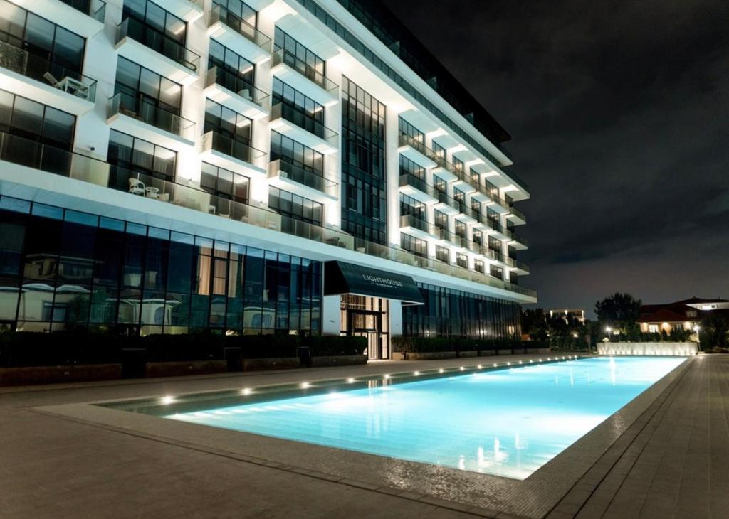 a swimming pool in front of a building at night at Sea breeze Lighthouse 2 in Baku
