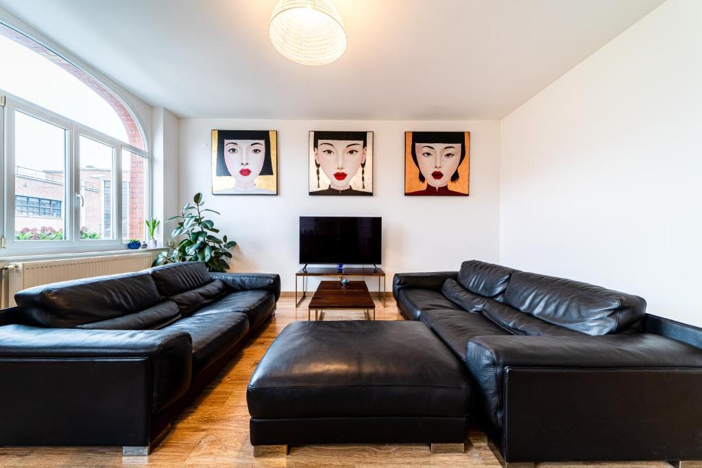 un salon avec des canapés en cuir noir et une télévision dans l'établissement Design & confort 6 pers Hypercentre Dunkerque, à Dunkerque