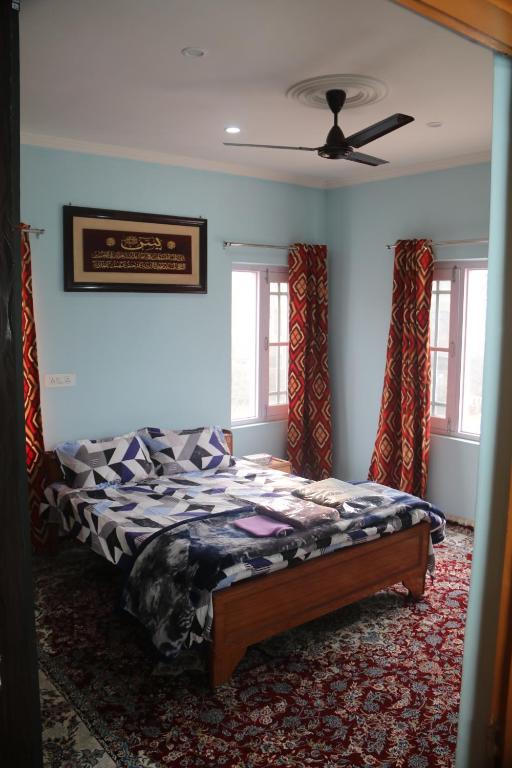 a bedroom with a bed and a ceiling fan at Baba BabaBah in Srinagar