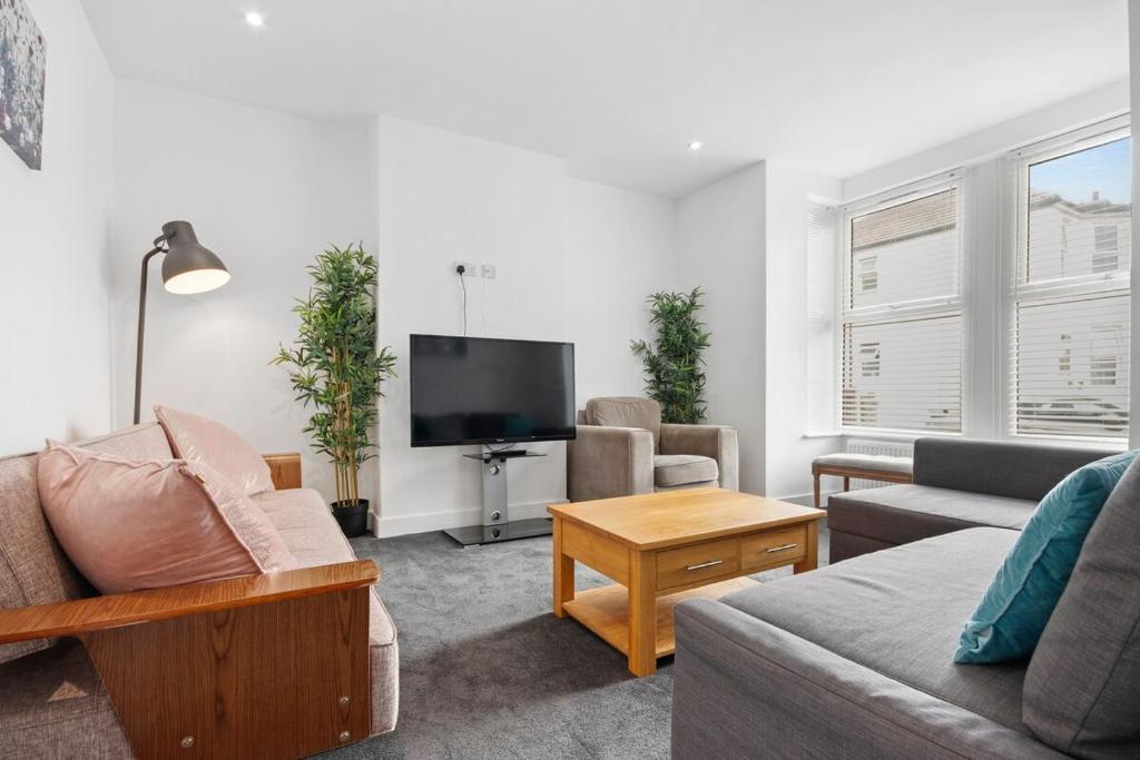 uma sala de estar com um sofá e uma televisão de ecrã plano em Victoria House Near Beach With Free Parking em Southend-on-Sea