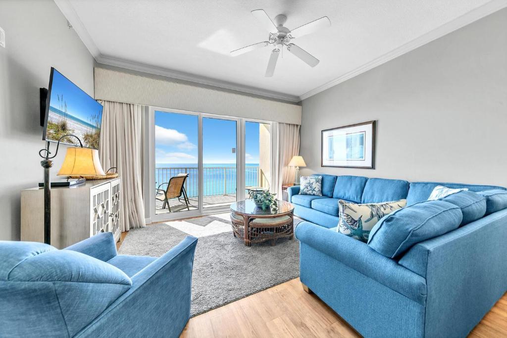 - un canapé bleu dans le salon avec vue sur l'océan dans l'établissement Grandview East 1504, à Panama City Beach