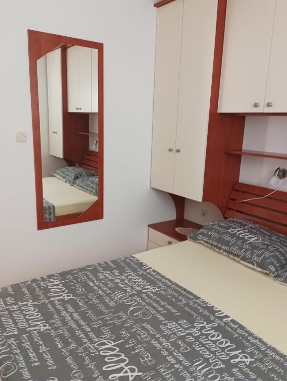 sypialnia z łóżkiem i lustrem w obiekcie Apartmani Ana Vir w mieście Vir