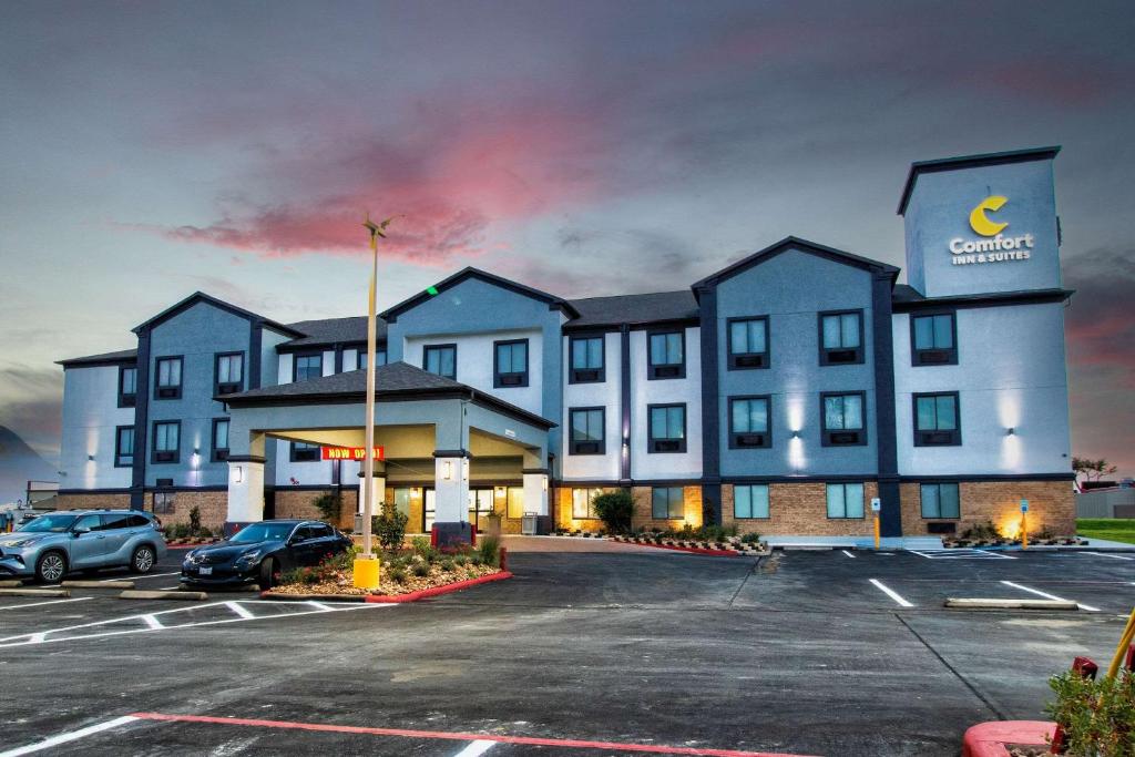 un hotel con un estacionamiento delante de él en Comfort Inn & Suites, en Schulenburg